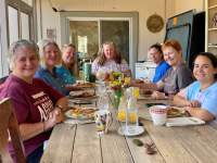 Breakfast on the screened porch Ladies sitting at a farmhouse style table enjoying breakfast on the screened porch.