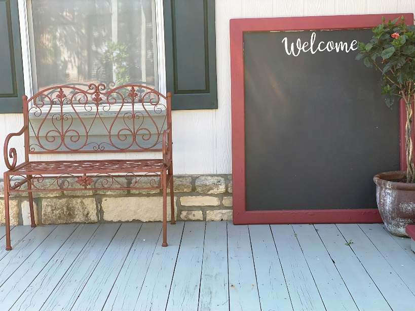 Red iron bench and red welcome board.
