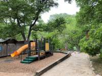 Tree covered park with children's playscape.