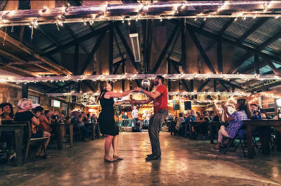 Patrons seated around a dance floor with a couple dancing.