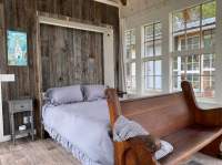 Open Murphy bed and antique church pew as a footboard.
