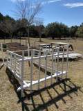 White trellis laid on its side on the ground. Garden in the background with chicken wire fencing.