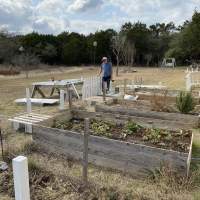 Man laying out and organizing fencing  materials.