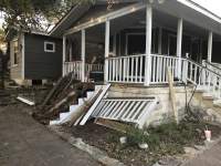 Front porch with damaged steps and handrails removed and new ones being installed.