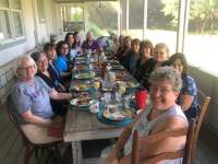 Girlfriends having breakfast on the screened porch.