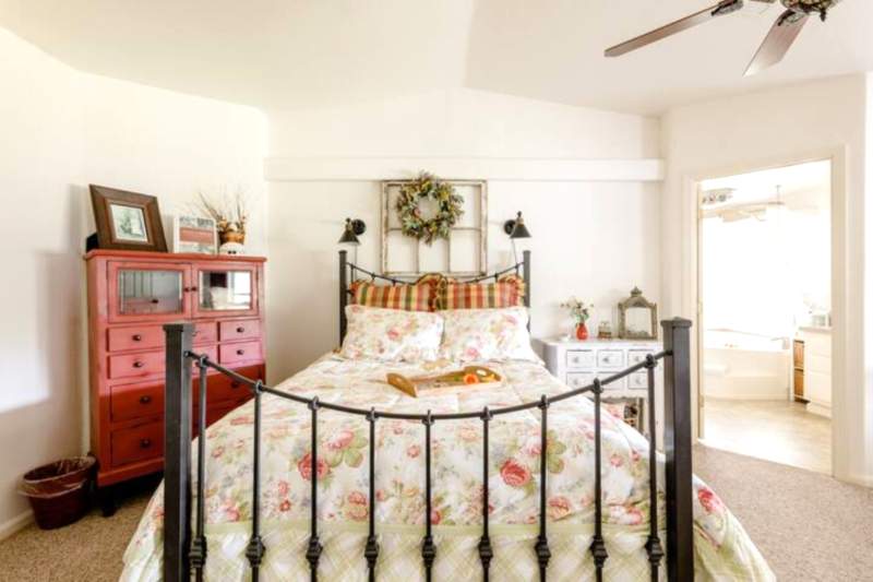 A spacious inn bedroom showing a queen bed and large bathroom with garden tub/shower.