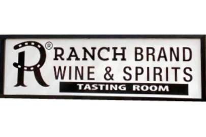 Ranch Brand Wine & Spirits Red round sign with large letter R in the center. Below it a sign with white background and in black the R logo and words: Ranch Brand Wine & Spirits Tasting Room.