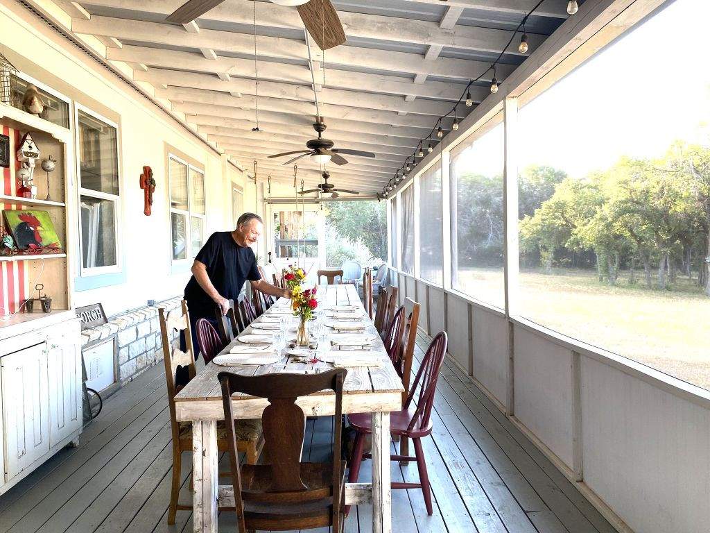 Breakfast on the screened porch - BellaVida Bed and Breakfast BellaVida owner, Steve sets the farmhouse table for breakfast on the screened porch.