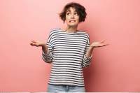 Woman holding up both palms gesturing indicating she is weighing the information to make a decision.