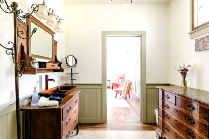 Elegant private bath furnishings with a view of the sitting area through the doorway.