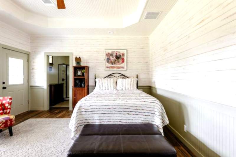 Whitewashed shiplap walls and warm woodgrain flooring, the suite captures the cozy elegance of a Southern cottage. Sitting area for comfortable TV viewing or workspace.